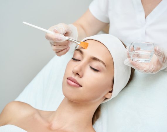 Cosmetology beauty procedure. Young woman skin care. Beautiful female person. Rejuvenation treatment. Facial chemical peel therapy. Clinical healthcare. Doctor hand. Dermatology cleanser.